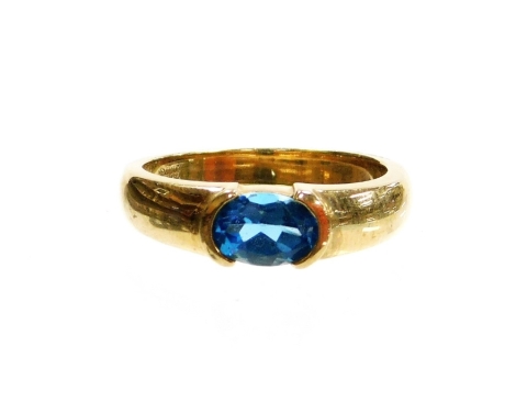 A 9ct gold dress ring, with tension set central oval cut blue stone possibly either topaz or a zircon, ring size l½, 3.4g all in, boxed.