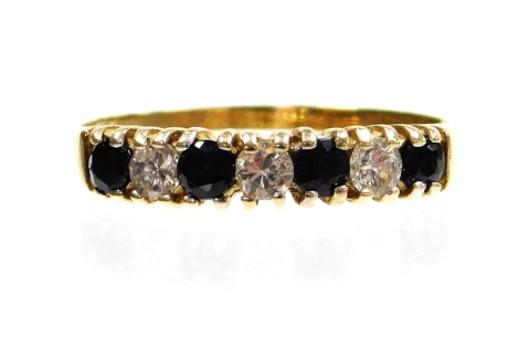 A 9ct gold half hoop eternity ring, set with three imitation diamonds and four dark blue stones, ring size Q½, 1.6g all in, boxed.