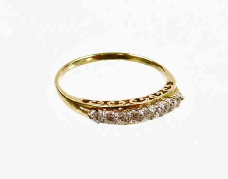 A stone set dress ring, of half hoop design set with imitation white stones on a pierced shank, yellow metal, unmarked, ring size W, 2.4g all in.