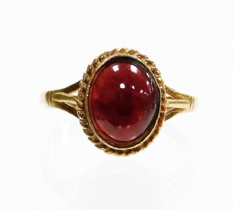 A 9ct gold dress ring, set with red cut stone with rope twist borders and V splayed shoulders, ring size Q, 2.7g.