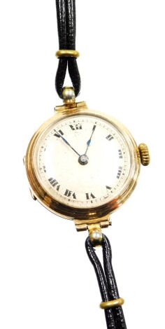 A 9ct gold cased gentleman's wristwatch, with small circular watch head on silvered dial with blue hands, 2.5cm wide, on a two row leather strap, 17.4g all in.