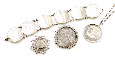 A group of silver and other coin jewellery, to include an 1890 one dollar coin in silver mount, a pisces medallion in silver frame on a silver curb link chain, a Victorian silver crested brooch with the initials GG and a two shilling six coin bracelet, wi