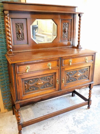 An early 20thC oak mirror back sideboard, with carved detailing and barley twist columns with single shelf above octagonal central mirror with two drawers and two cupboards, on rectangular base 163cm high, 121cm wide, 49cm deep.