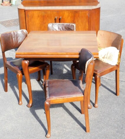 A Queen Anne style walnut dining suite, comprising sideboard, table and chairs, the curved top with two cupboard doors with metal cup ends opening to reveal a light wood interior on splayed legs, 108cm high, 135cm wide, 49cm deep, and a set of four associ