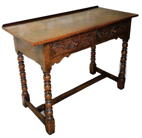 A carved oak hall table, with two frieze drawers, on bobbin turned legs, 76cm high, 106cm wide, 48cm deep.