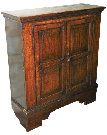 A late 18th/early 19thC oak hall cupboard, with two tall panelled doors, on a plinth base with later chipboard shelf inserts, 104cm high, 92cm wide, 30cm deep.