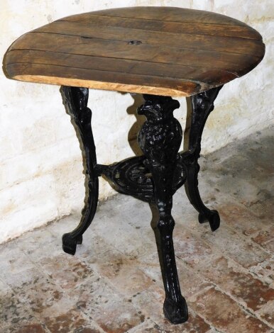 Pub Interest. A rustic cast iron base pub table, with wooden slat top and cut out centre section on a cast tripod base, 67cm high, 55cm diameter. (missing panel) (AF)