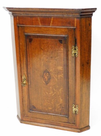 An early 19thC oak and mahogany and marquetry inlaid corner cabinet, the top with four door sections, above a central shelf depicting cannon and flowers, with brass supports, moulded cornice, 101cm high, 66cm wide, 43cm deep.