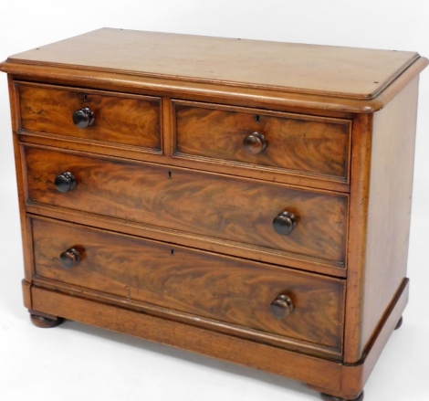 An early 19thC mahogany and veneered mahogany chest of drawers, with two short and two long drawers, with knob handles, 82cm high, 104cm wide, 52cm deep