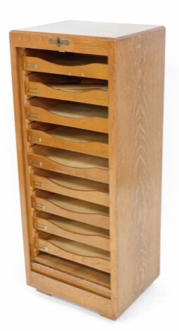 A 1930's filing cabinet, with tambour shutter and arrangement of twelve drawers, 116cm high, 47cm wide, 38cm deep.