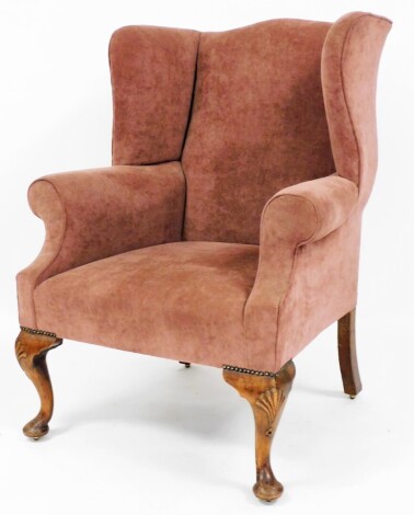 A wingback arm chair, modern upholstery in a plum material, on walnut cabriole legs, 110cm high, 83cm wide, 70cm deep.