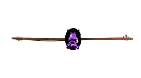 An amethyst set bar brooch, with oval cut amethyst in full claw setting, on a white gold backing, stamped 9ct, 6cm wide, 2.7g all in, boxed.