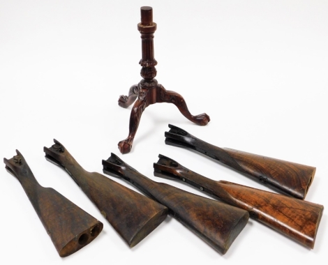 A group of treen, to include a tripod, ball and claw mahogany table base and five gun butts. (6)