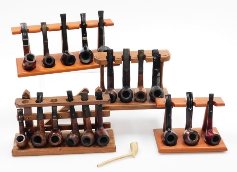 Three wooden pipe racks and assortment of various pipes.