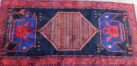 A deep blue ground rug, with large central medallion, on Greek key borders, with patch repair, 323cm x 153cm.