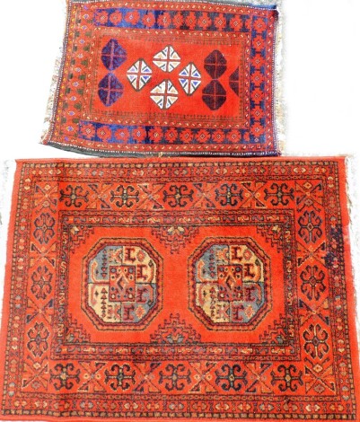 Two middle Eastern prayer rugs, to include one with stag and medallion border and Greek key surround, 50cm x 62cm, together with another on orange ground with medallion border and tassel ends, 91cm x 67cm. (2)