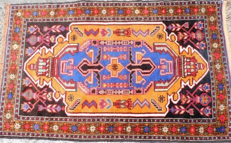 An Iranian multicoloured bordered rug, the star border with elongated central Aztec design medallion, on tassel ends, 146cm x 90cm.