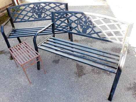 A pair of metal slated garden benches, each with rose basket finial, together with a small side table, 76cm high, 114cm wide, 52cm deep.