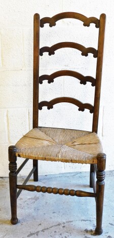 An Edwardian oak rush seated high back chair, the back with four arch column supports, on a rush seat, 98cm high, 42cm wide, 35 deep.