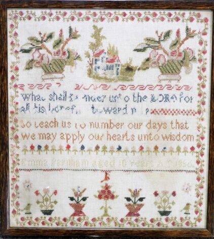 A 19thC alphanumeric needlework sampler, with various cross stitching of flowers and words, in a maple frame, 43.5cm x 40cm.