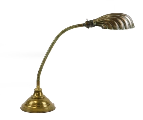 A retro brass desk lamp, with shell clam shade, on arched column, 74cm high.