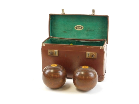 A cased set of carpet bowls, each carved wood detailed with crest emblem, in leather green lined case, marked Lehna Vulcan.