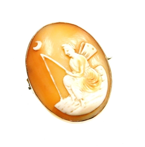 A late 19thC oval cameo brooch, with cameo figure fishing under moonlight, in a yellow metal frame, stamped 9C, with brass safety chain, 3.5cm x 2.5cm, 7.3g all in.