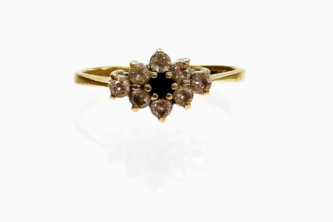 A 9ct gold dress ring, with central floral cluster set with dark blue stone, and white stones, ring size K, 1.8g all in.