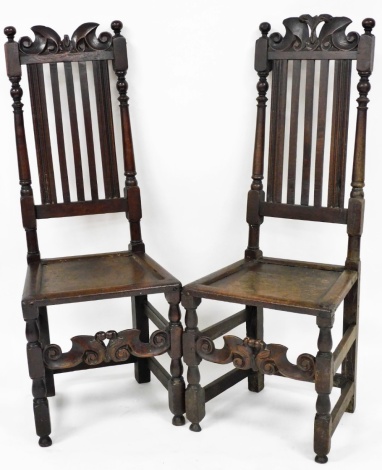 A pair of late 17thC oak high back chairs, the carved panel back, on five splat support, with a drop in seat on column base, 124cm high, 45cm wide, 38cm deep.