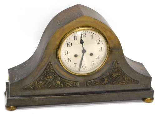 An unusual early 20thC patinated brass mantel clock, of arched form with two panels, each decorated with roses in Arts and Crafts manner, on bun feet, 55cm wide.