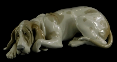 A Lladro porcelain figure of a recumbent hound, 25cm long.