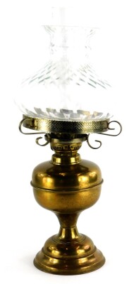 A 20thC brass oil lamp, with clear shade, on domed foot, 52cm high.