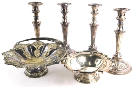 A set of four silver plated candlesticks, each with a reeded column and a domed foot, 28cm high, and two silver plated baskets. (6)