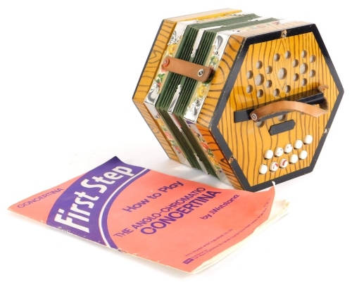 A Scholeb wooden concertina, with simulated painted wood grain, printed floral bands, etc., and a book.