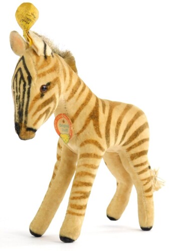A vintage Steiff Zebra, with original paper label and pin or button to ear, 17cm long.