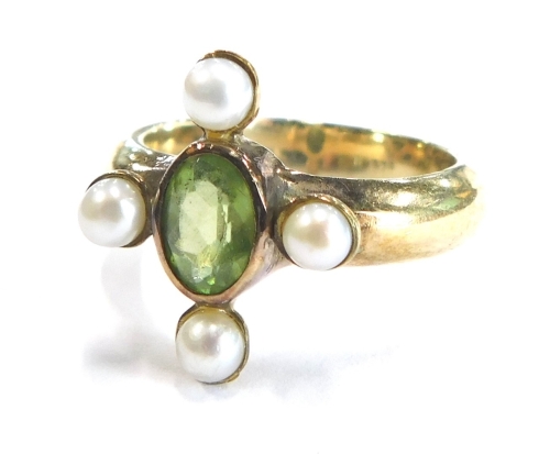 A modern dress ring, the central design set with peridot and four seed pearls, on a gold coloured band possibly stamped 925, ring size O½, boxed.
