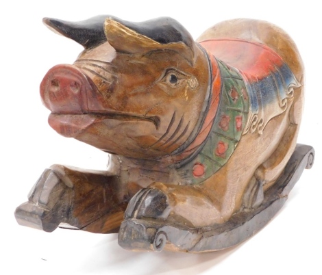 An Eastern carved hardwood rocking pig, with polychrome painted saddle etc., on scrolled carved runners, possibly Indian, 60cm long.