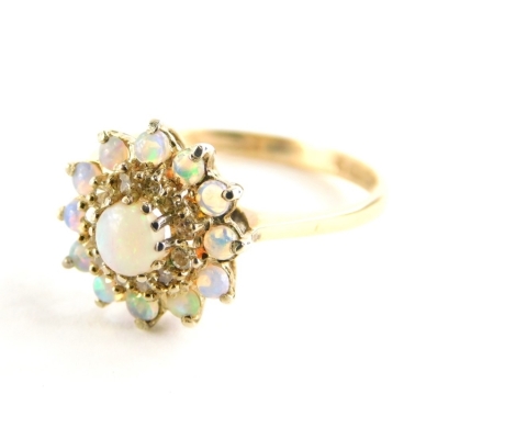 A 9ct gold opal and diamond dress ring, with central opal surrounded by a halo of diamonds and a further surround of opals, each in claw setting, ring size N½, 2.3g all in.