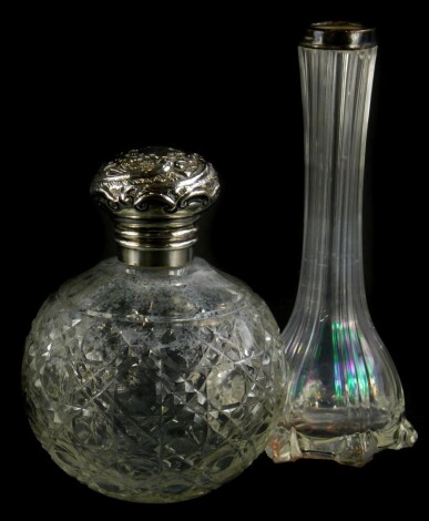 An Edwardian cut glass scent bottle, with silver mount, embossed with scrolls, etc., Birmingham 1902, and a glass vase with silver collar. (2)