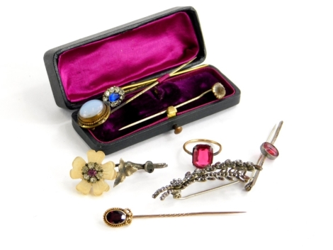 A group of costume jewellery, to include a rolled gold and paste stone dress ring, three bar brooches, a yellow metal and garnet set stick pin, unmarked, a moonstone stick pin, and two paste stone set pins. (8)