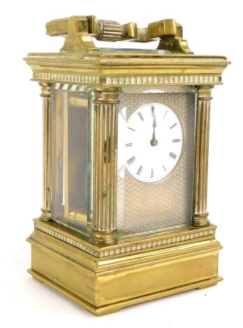 A late 19th/early 20thC French miniature carriage clock, with engine turned decoration, surrounding the enamel dial with Roman numerals, flanked by reeded pillars, stamped to underside Depose, 11cm high.
