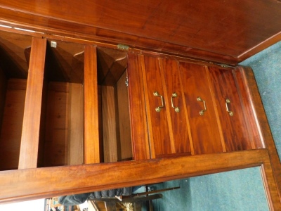 A Victorian figured mahogany triple wardrobe, with a moulded cornice above a central mirror, flanked by two panelled doors, enclosing sliding trays, drawers and recesses, on a plinth, 207cm high, 197cm wide. - 2