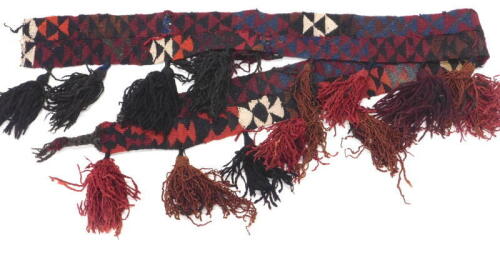 A Persian Kilim tent hanging or harness, with a geometric design and large tassels, 200cm x 12cm approximately.