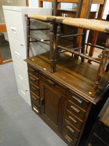 A pair of two drawer metal filing cabinets, a pair of bedroom chairs with rush seats, and an oak cabinet, (a quantity).