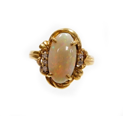 An opal and diamond dress ring, the oval opal in four claw setting with rococo scroll bordering and diamond set shoulders, with three tiny diamonds to one side and two to the other, on a raised shank, yellow metal stamped 750, ring size T, 6.1g all in.