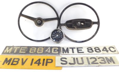 A Smith's vintage dashboard speedometer, with mileometer and fuel gauge, together with two vintage steering wheels, and four number plates. (7)