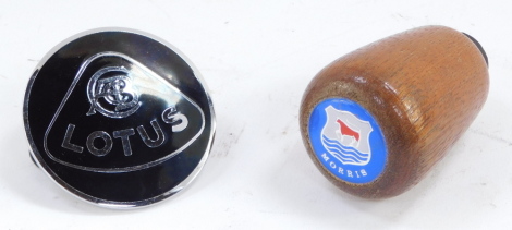 A Lotus metal and black enamel car badge, together with a Morris gear stick knob. (2)