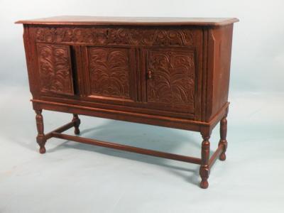 An early 20thC carved oak sideboard with an arrangement of two doors on