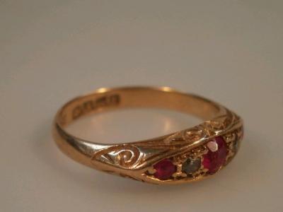 A 18ct gold boat shape ring set with three small rubies and two small diamonds