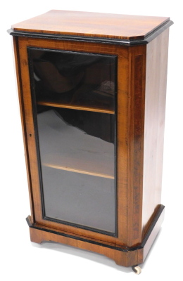 A narrow Victorian walnut and ebonised display cabinet, the top with canted corners, above a glazed door, on bun feet, 96cm high, 53cm deep.